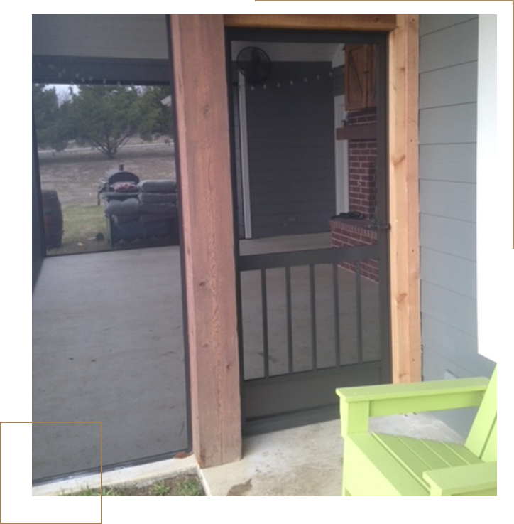 A green chair in front of a screen door.