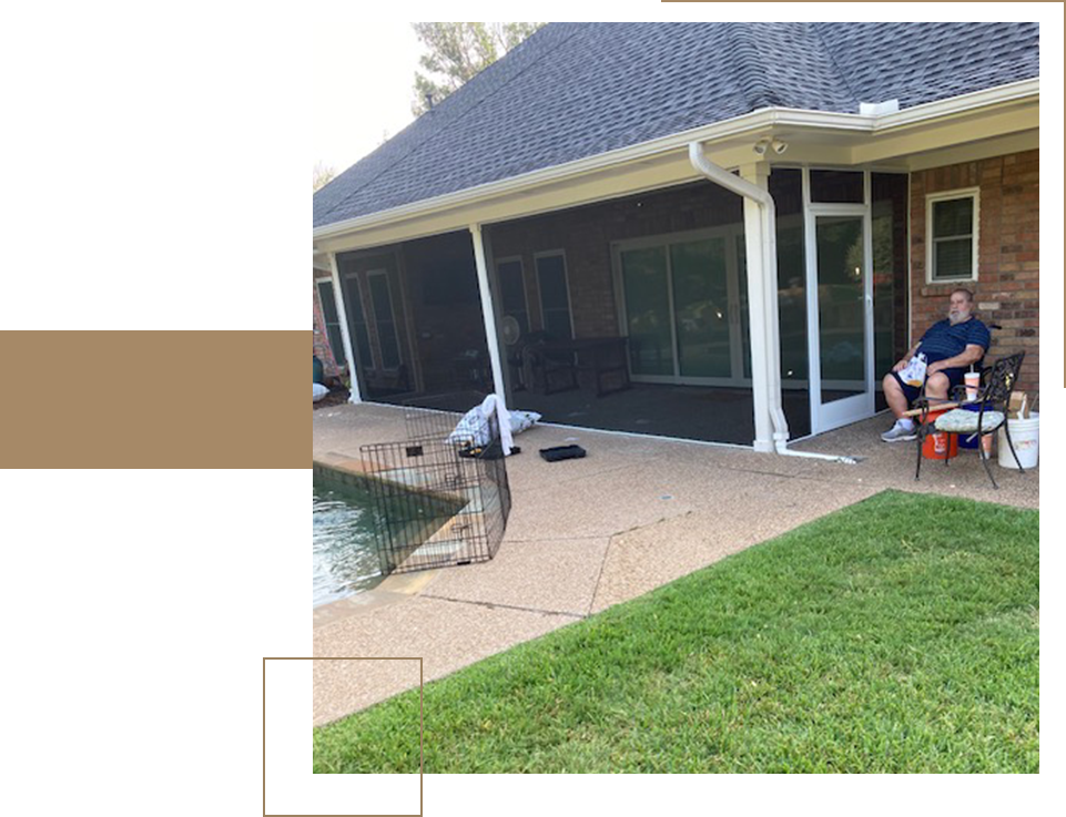 A man is standing on the patio of his house