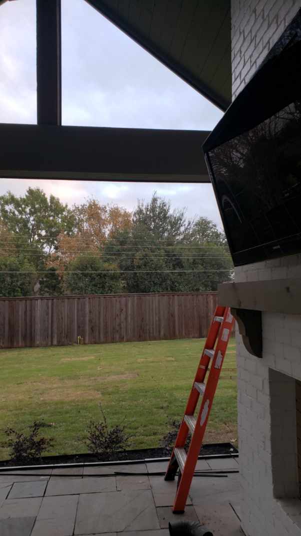 A ladder is in the foreground of an outdoor area.